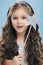 Close up shot of adorable blue eyed small European female princess has long wavy hair, wears crown, holds star magic wand,