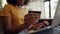 Close-up shot of an african american woman holding a credit card in her hand doing internet banking using laptop