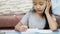 Close up shot Asian little girl using pencil doing homework and talk to smartphone