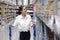 Close up shot of Asian pretty customer searching products in store warehouse. The girl pushing the cart and find the goods to put