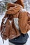 Close-up shot of backpack on woman while walking in winter forest, snow on backpack