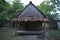 Close up shot of a bamboo bungalow hostel with a thatch roof made of palm tree leaves, a wooden foundation, patterns on the walls