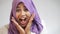 Close up shot of beautiful Asian muslim woman wearing hijab shows shocked excited expression, toothy smile, surprised to see somet