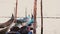 Close-up shot of beautiful traditional gondola boats with rain covers rocking heavily on big waves at pier in Venice.