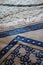 Close up shot of blue islamic prayer rug on modern Turkish carpet