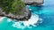 Close up shot of blue waves crashing on the tropical rocky cliffs and sandy beach Top down view of turquoise tropical ocean, cliff
