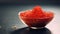 A close-up shot of a bowl filled with vibrant red trout caviar placed elegantly on a sleek concrete table in a modern