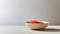 A close-up shot of a bowl filled with vibrant red trout caviar placed elegantly on a sleek concrete table in a modern
