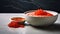 A close-up shot of a bowl filled with vibrant red trout caviar placed elegantly on a sleek concrete table in a modern