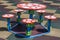 Close-up shot of bright colorful new round child small table and five stools outdoors on square rubber flooring on kindergarten pl