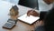 Close-up shot of Businesspeople use a pen to write on a tablet with model house and a calculator on the table