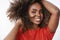 Close-up shot of carefree relaxed and tender african-american female model in red t-shirt playing with curly hair