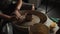 Close-up shot of ceramic cup spinning on potters\'s wheel and hands molding clay