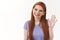 Close-up shot cheerful, friendly nice smiling redhead girl, waving raised arm in hello, hi gesture, tilt head and