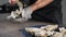 Close-up shot of chef opening fresh oysters with knife wearing protective metal glove. seafood restaurant. Slow motion