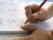 Close-up shot of child hands writing in the book