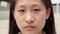 Close up shot of Chinese teenage girl looking at serious camera. Intense look of a young Asian girl.