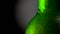 Close up shot of cold beer green bottle with water drops. Rotation 360, black background. UHD, 4K