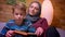 Close-up shot of concentrated small boy and his muslim mother in hijab learnin how to read being attentive at home.