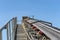 Close-up shot of the conveyor belt in the concrete plant with transport rollers, visible metal stairs and railings.