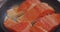 Close-up shot of cooking big beautiful pieces of red fish fry in boiling oil in a frying pan, food concept. Pieces of
