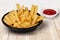 Close Up Shot Of Crinkle Cut French Fries In The Black Disposal Bowl And Ketchup Tomato Sauce On The Side