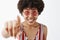 Close-up shot of curious excited and amused attractive happy dark-skinned woman with curly hair in striped blouse and