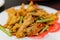 Close up shot of a dish of deep fried pork meat with salted duck egg and vegetable