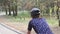 Close up shot of female cycling riding bike in a park wearing black helmet and blue jersey. Slow motion