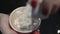 Close-up shot of female hands adding sweet marshmallow to cup of hot coffee