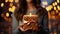 Close up shot of female hands holding a small gift wrapped with ribbon. Small gift in the hands of a woman indoor