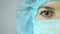 Close-up shot of female medical worker wearing face mask looking into camera