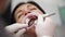 Close-up shot of female patient having zirconia veneers installation procedure. Installing white veneers on woman teeth