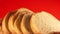 Close-up shot of a fresh sliced loaf rotates. Freshly baked baguette on a bright orange background. Fresh bread rotates. Selective