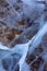 Close up shot of frozen waters with included of cracks, bubbles and herbs of baikal lake ice