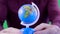 Close-up shot of a globe that is hold by a geographer,reminding for us that the Earth isn`t so big.We must take care and protect