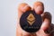 Close up shot Golden Ethereum ETH included with Cryptocurrency on hand business man wearing a blue suit. Filed and put and give to