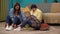 Close up shot of grandmother, her daughter and grandson sitting on the floor in the room playing with toy constructor.