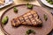 Close-up shot of grilled T-bone steak with chilis served with brown plate in restaurant