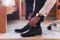 Close up shot of a groom tying his shoes and preparing for the wedding