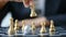 Close up shot hand of business woman moving golden chess to defeat a silver king chess on white and black chess board for business