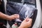 Close up shot hands of man removing old car window film focus on