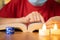 Close up shot of hands reading bible with candles in front on decorated Christmas background during xmas festival