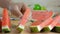 Close up shot hands of woman arranging a piece ripe watermelon on wooden cut board fresh fruit for summer