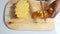 Close up shot hands of women using kitchen knife to cutting and peeling ripe pineapple shallow depth of field