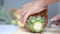 Close up shot hands of women using kitchen knife to cutting and peeling ripe pineapple shallow depth of field