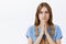 Close-up shot of hopeful serious-looking determined cute young woman with chestnut hair standing concerned holding hands