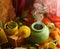 Close-up shot of a hot teapot surrounded by colorful materials and leaves