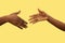 Close up shot of human holding hands isolated on yellow studio background.