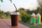 Close-up shot of iced cocoa drink in a plastic cup, ready to eat and then throw away on a wooden table, selectable focus